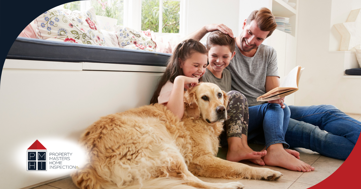 Smiling family sitting on the floor with their golden retriever.