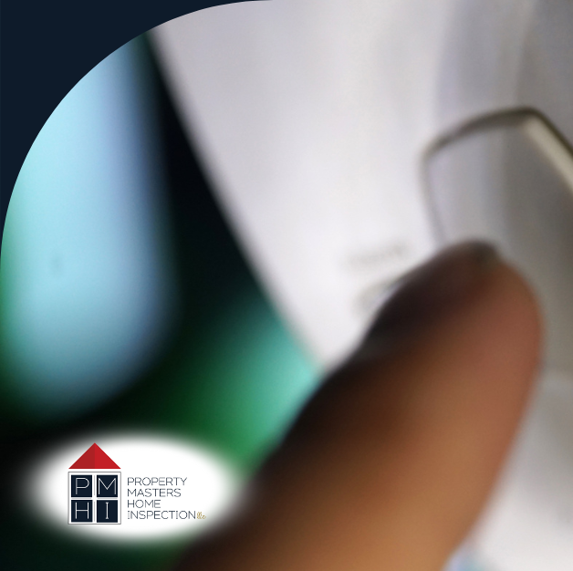 A person pressing the button on a carbon monoxide alarm.