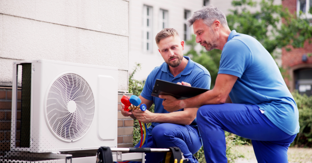 HVAC technicians inspecting an outdoor air conditioning unit.